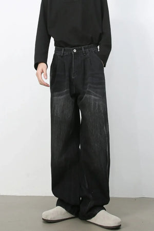 Dark wash pleated wide-leg denim trousers with distressed details
