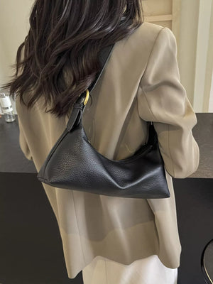Black minimalist PU leather crossbody bag with adjustable strap and gold hardware detail.