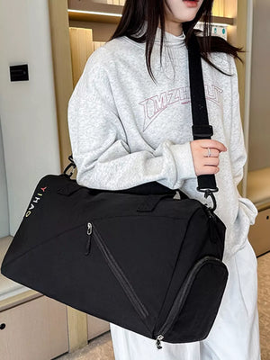Black duffel bag with colorful logo and zippered pockets, worn crossbody.