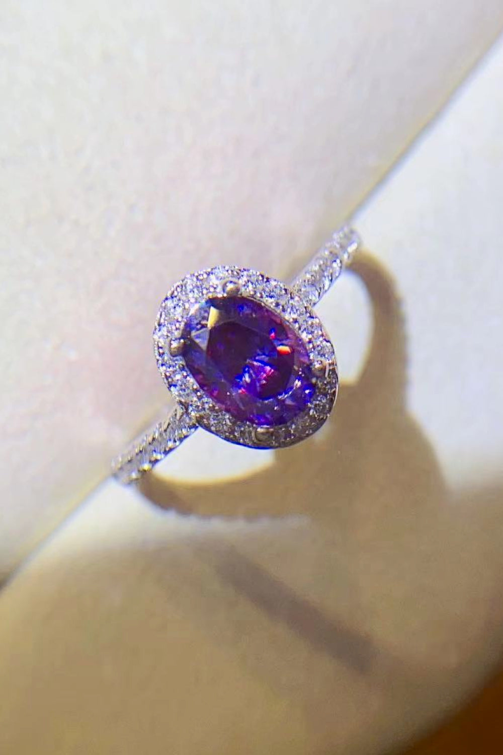 Silver ring with oval purple moissanite and diamond halo
