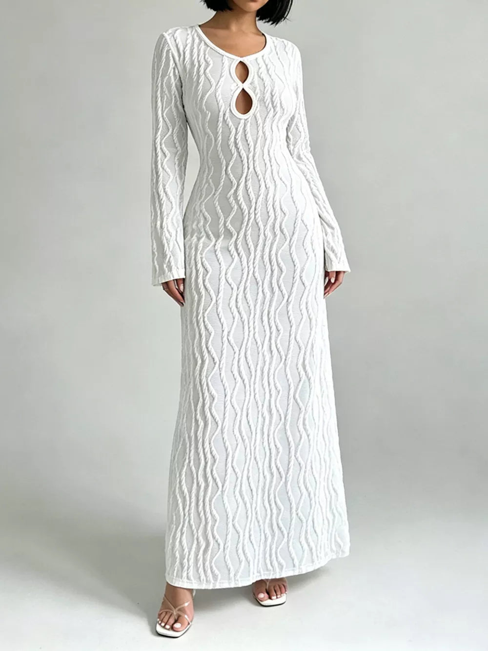 White long sleeve maxi dress with textured wavy pattern and keyhole cutout neckline.