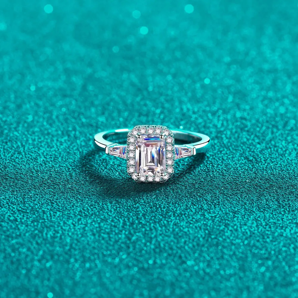 Emerald cut moissanite halo ring in sterling silver with baguette accents