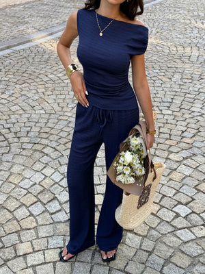 Navy ruched asymmetrical one-shoulder top with wide-leg drawstring pants set.
