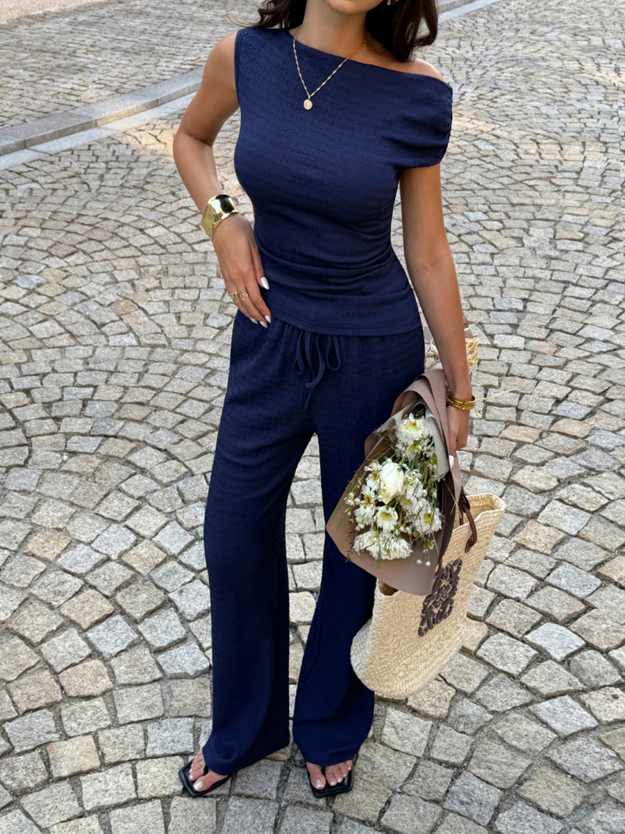 Navy ruched asymmetrical one-shoulder top with wide-leg drawstring pants set.