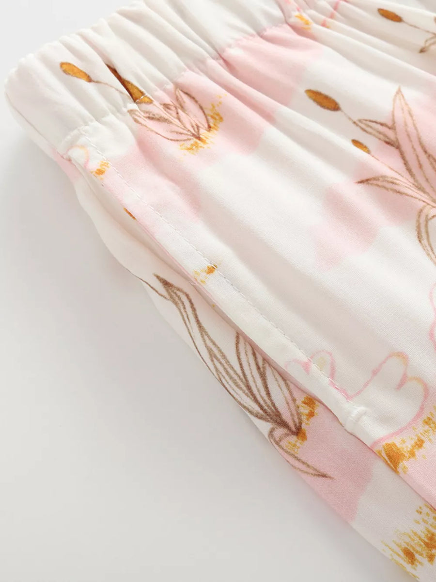 Toddler blush floral print cotton trousers with elastic waist and pockets.