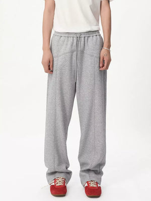 Gray cotton sweatpants with drawstring waist and wide legs.