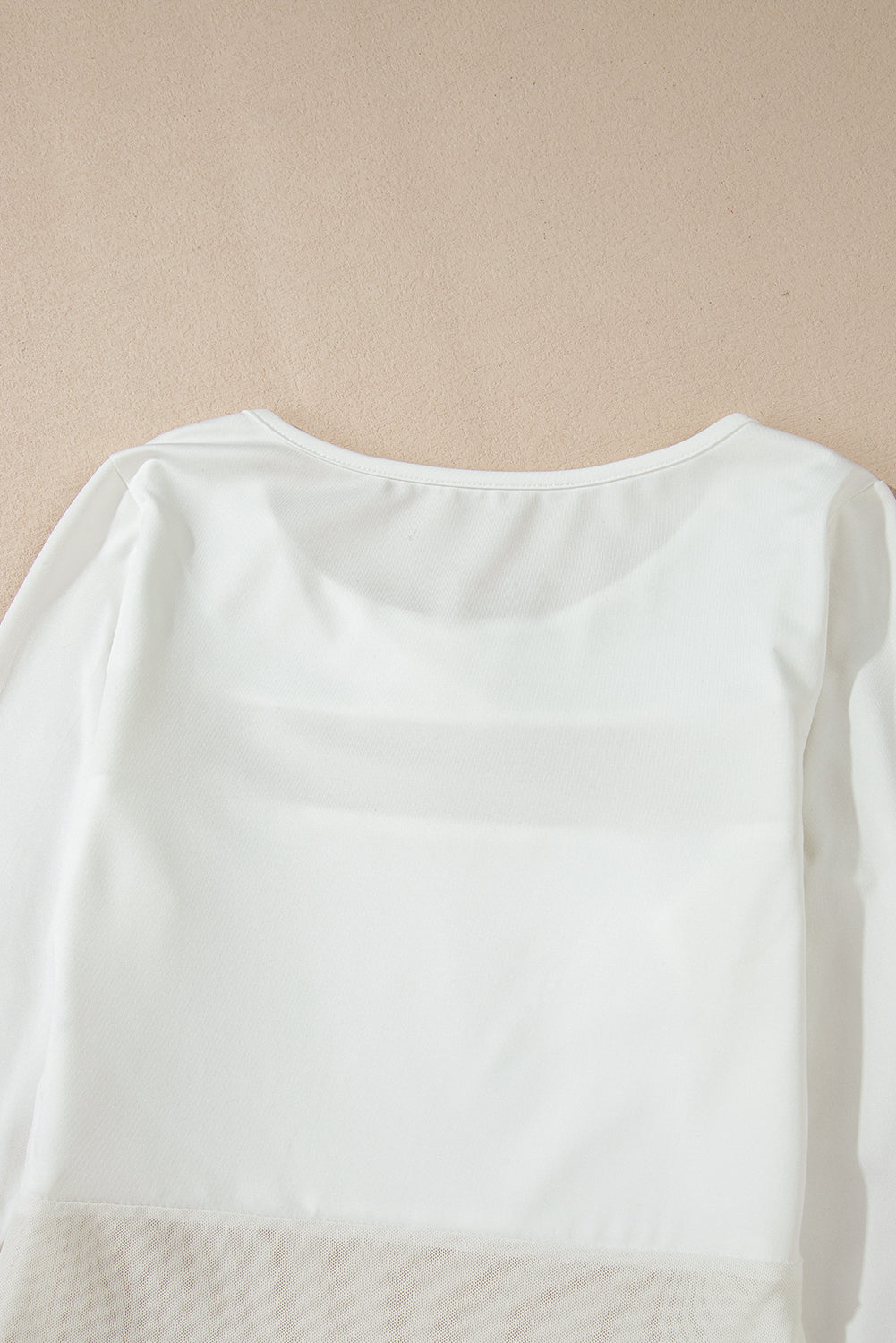 White long sleeve bodysuit with sheer mesh panel detail at the hem.