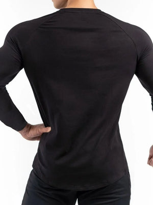 Black long sleeve performance top with raglan sleeves and a curved hem.