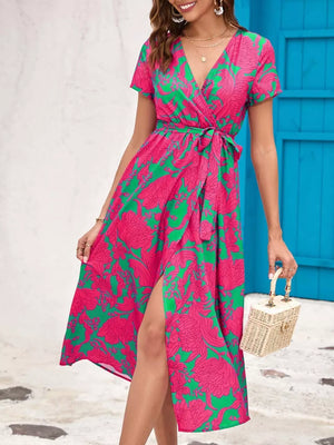 Wrap dress with short sleeves, V-neck, tie waist, and high slit in a pink and green floral print.