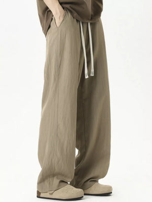 Men's khaki track pants with drawstring and relaxed fit.