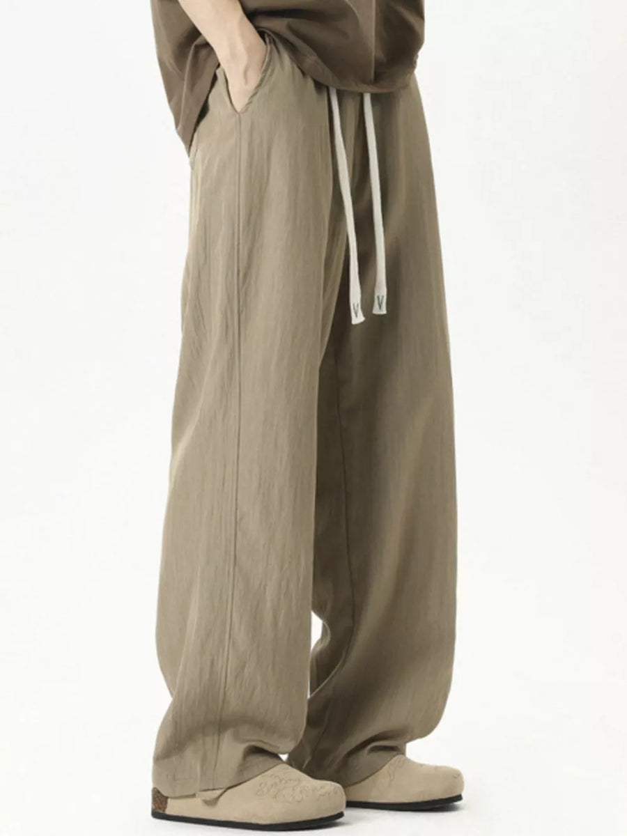 Men's khaki track pants with drawstring and relaxed fit.