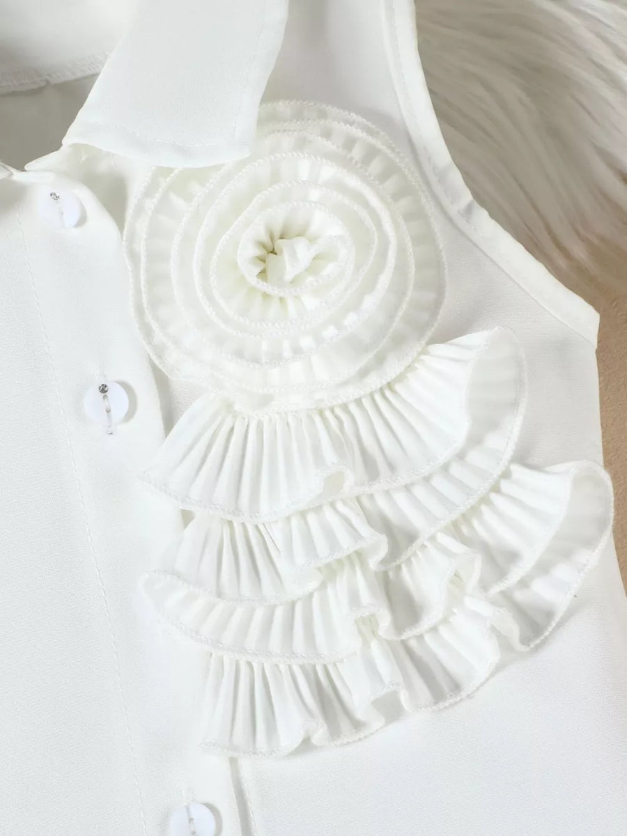 White ruffled applique top with decorative buttons and a collared neckline.