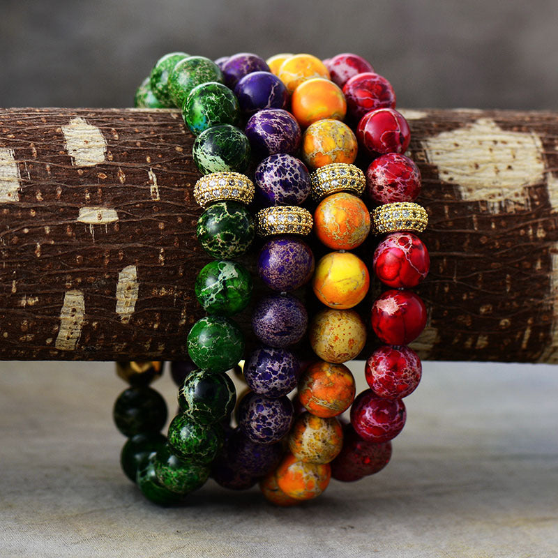 Rainbow Jasper bead bracelets with gold accents in green, purple, orange, and red.