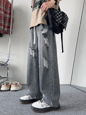 Oversized distressed wide-leg jeans in dark gray denim with a drawstring waist.