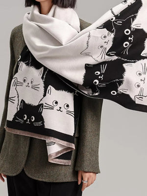 Reversible black and white cat pattern scarf with fringe detail.