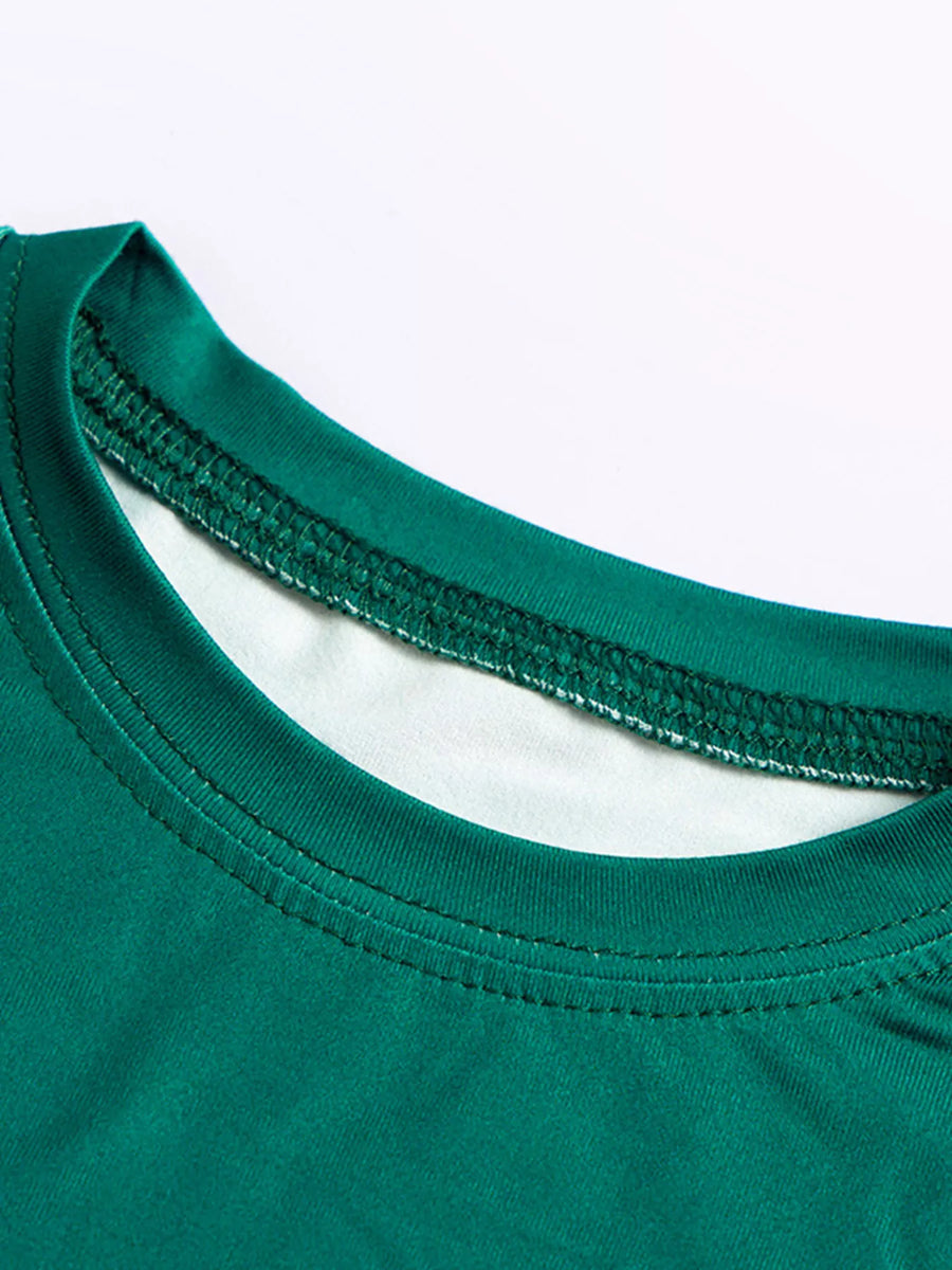 Dark green kids' pajama set with dinosaur print, showing neckline detail.