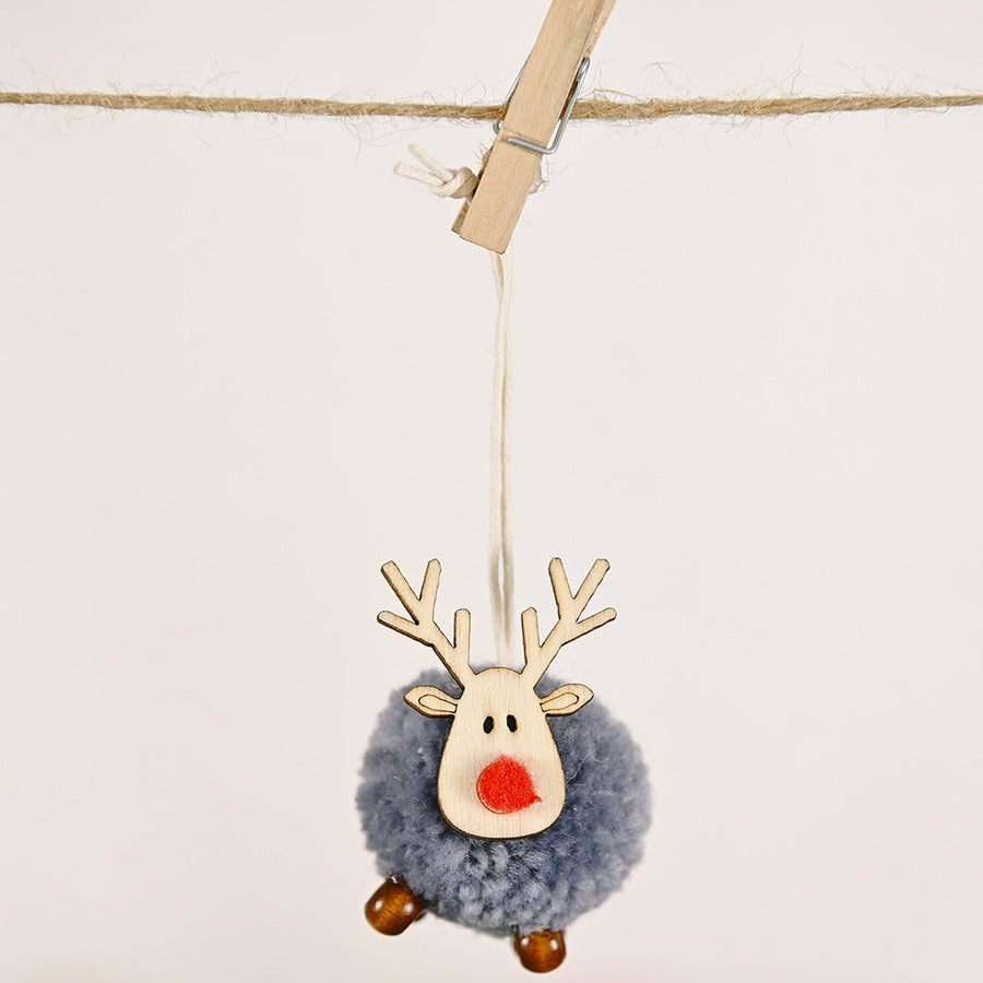 Multicolor pom-pom reindeer ornament with wooden antlers and red nose.