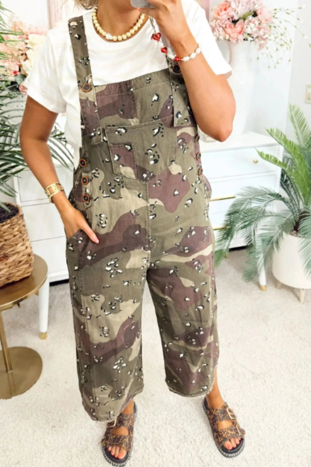 Cropped denim overalls in camouflage with leopard accents, featuring button details and pockets.
