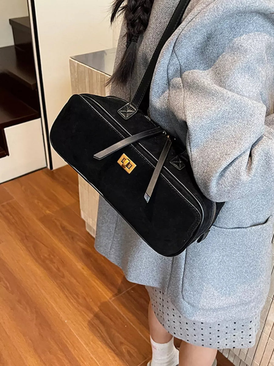 Black suede shoulder bag with gold clasp and contrast stitching