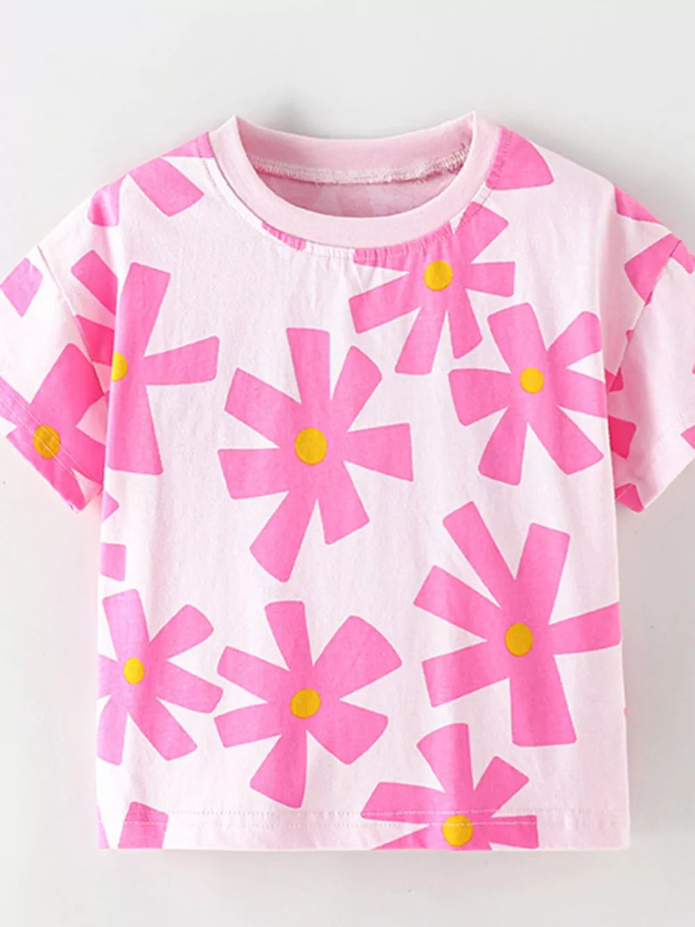 Pink cotton t-shirt for kids with a playful pink floral print and yellow centers.
