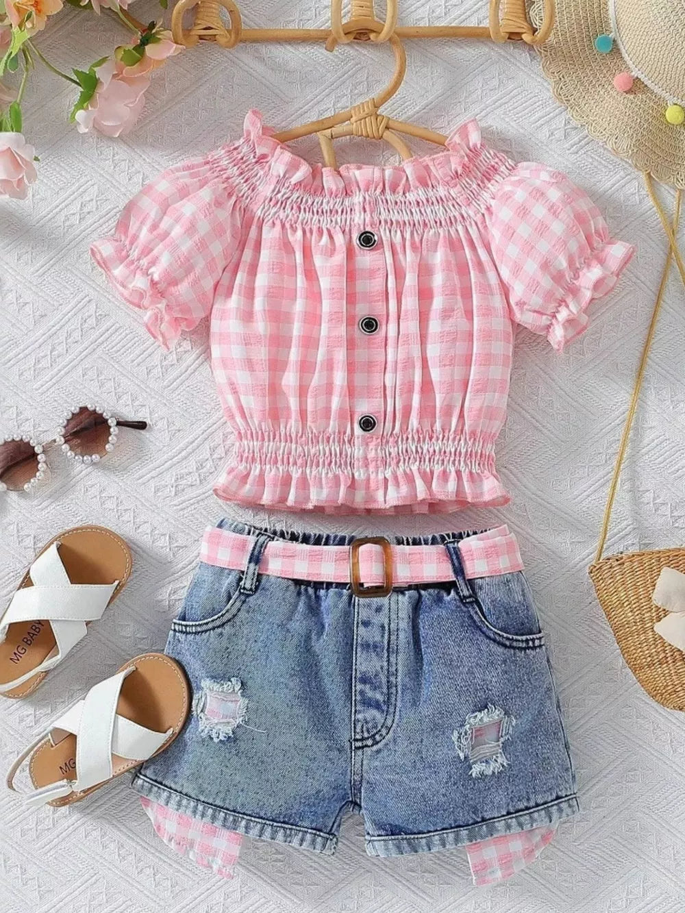 Pink gingham off-shoulder top with ruffled sleeves and denim shorts with distressed details and matching belt.