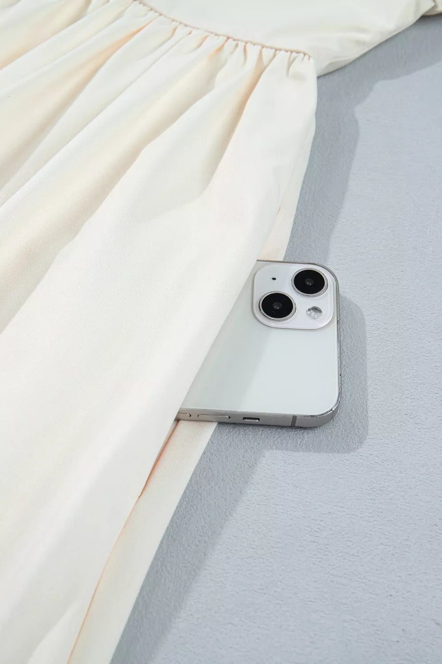 Cream floral puff sleeve A-line dress with side pocket detail shown with a phone.