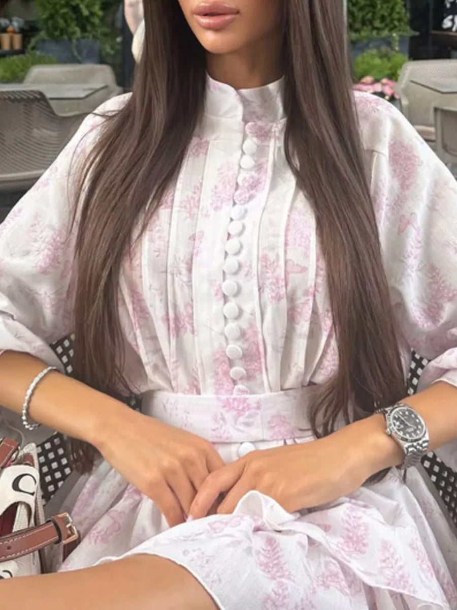 White floral print dress with high neck, button front, and puff sleeves.