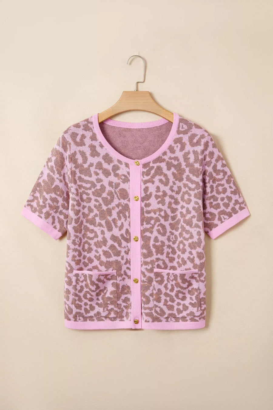 Short sleeve leopard print cardigan with button front and pockets in acrylic blend.