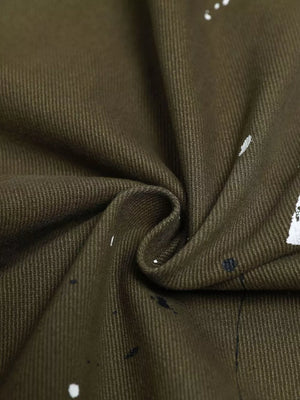 Olive green cotton cargo pants with white and black paint splatter detail.
