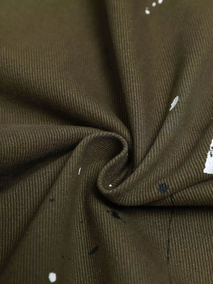 Olive green cotton cargo pants with white and black paint splatter detail.