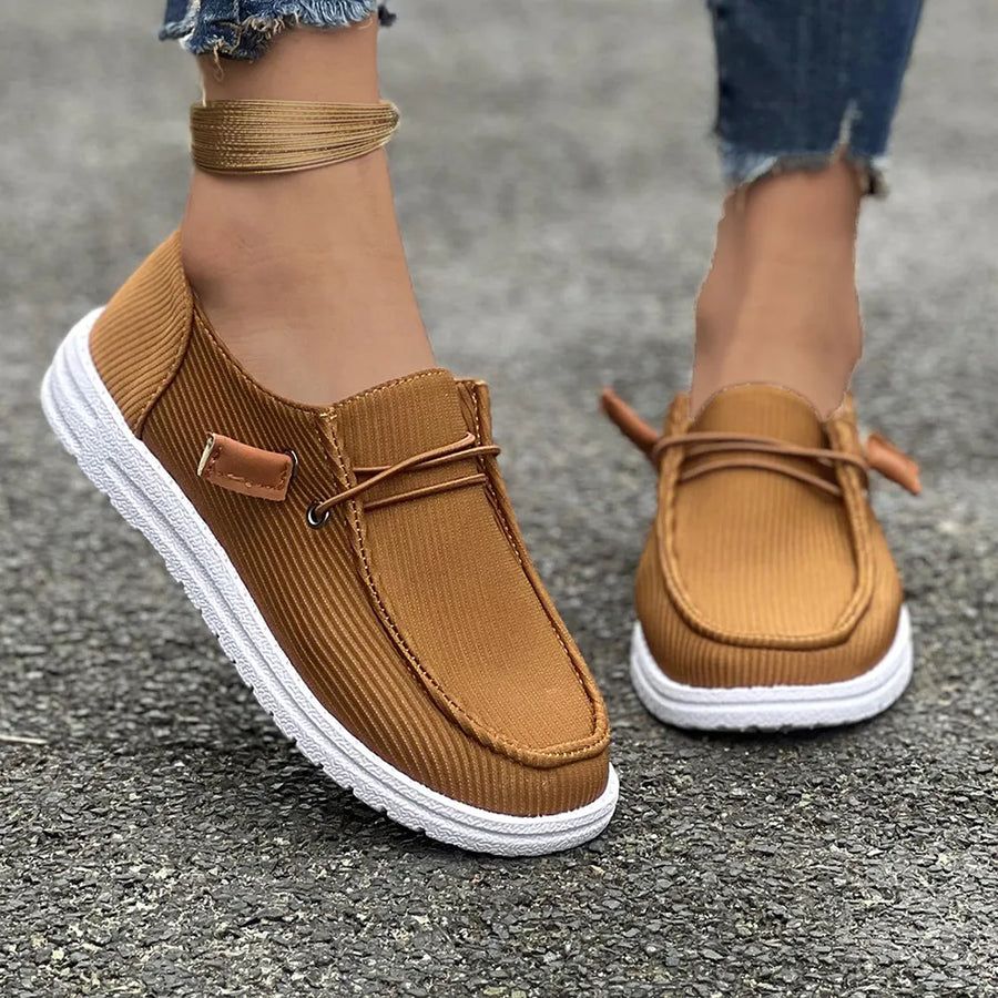 Caramel corduroy boat shoes with lace detail and white soles.