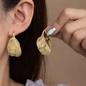 earrings in gold featuring textured and drop fit