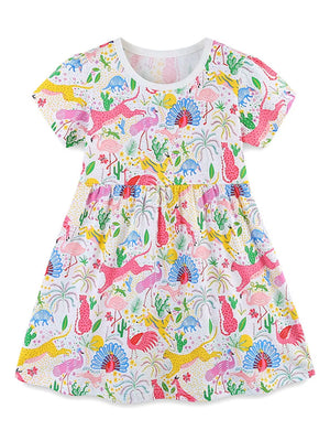 White cotton blend dress with a colorful animal and dinosaur print, short sleeves, and gathered waist.