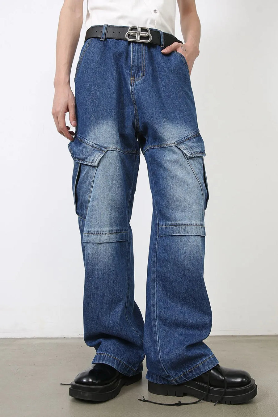 Cargo denim flare trousers in medium wash blue with multiple pockets and a relaxed fit.
