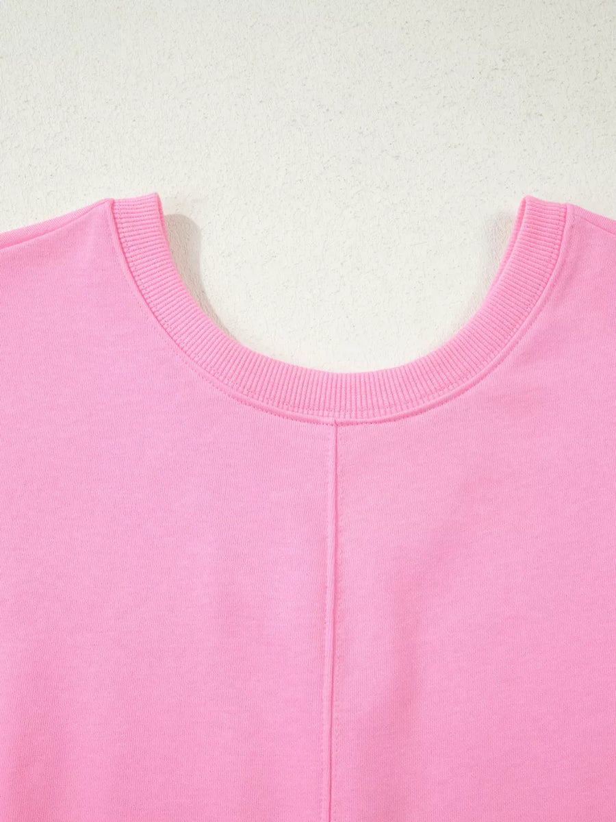 Pink cotton romper with crew neck and center seam detail