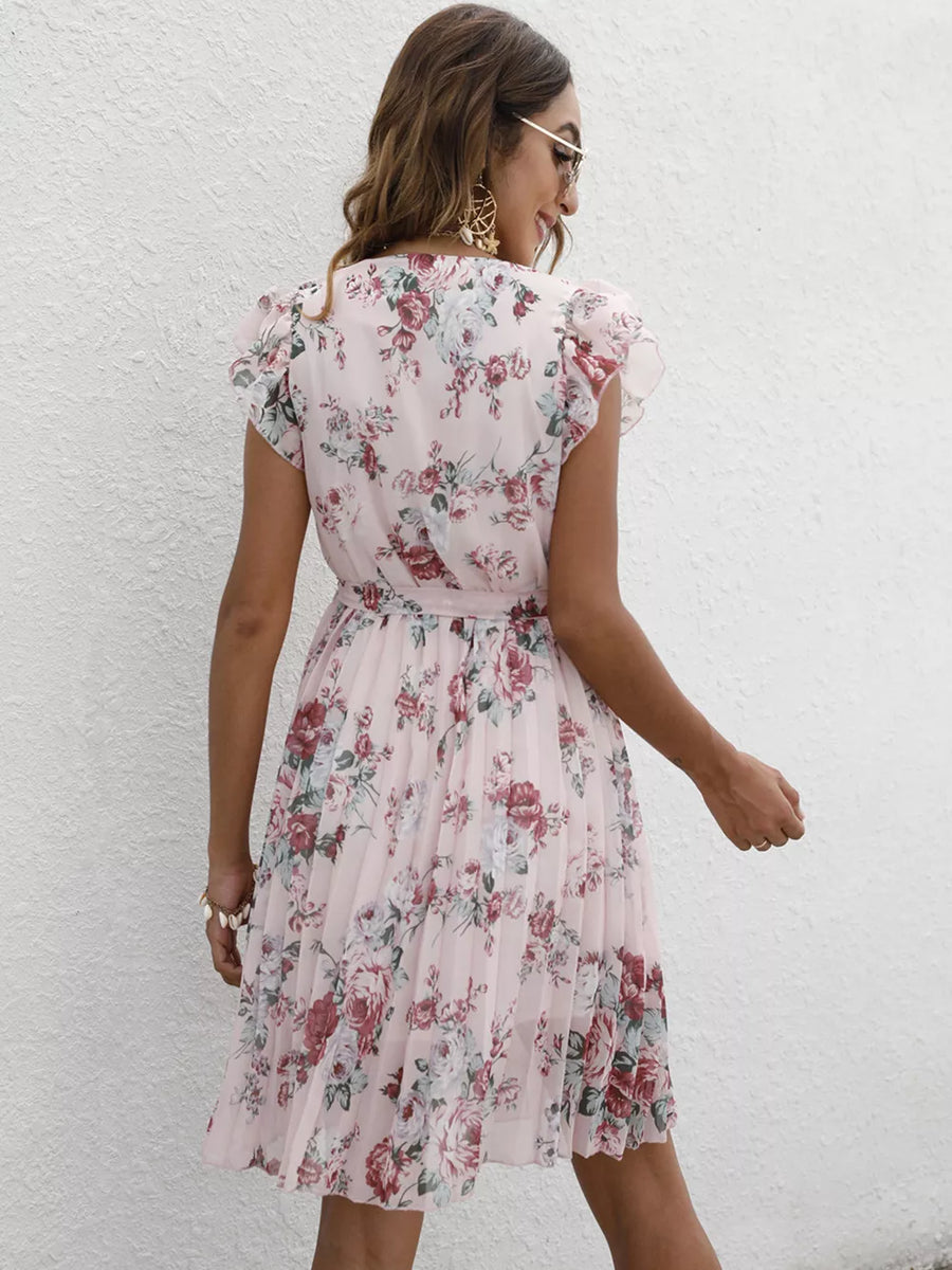 Blush pink floral pleated dress with ruffle sleeves and a belt.
