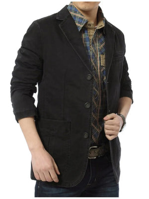 Black cotton blazer with lapel collar, buttoned front, and flap pockets.