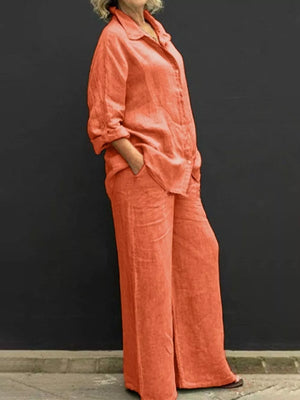 Orange linen two-piece set with buttoned collared top and wide-leg pants.