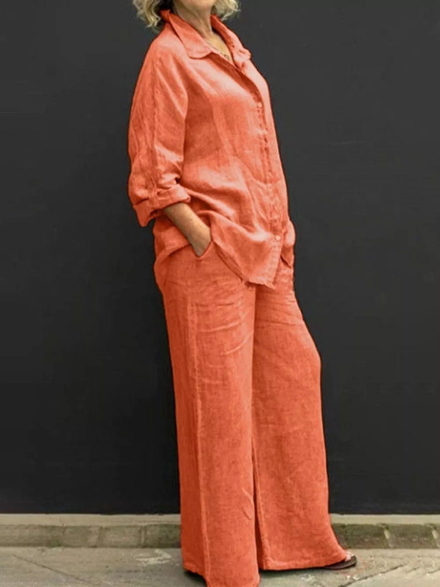 Orange linen two-piece set with buttoned collared top and wide-leg pants.