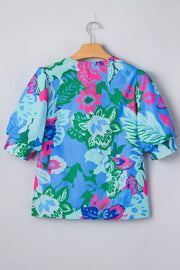 Vibrant floral v-neck blouse with relaxed fit and puff sleeves in blue, green, and pink.
