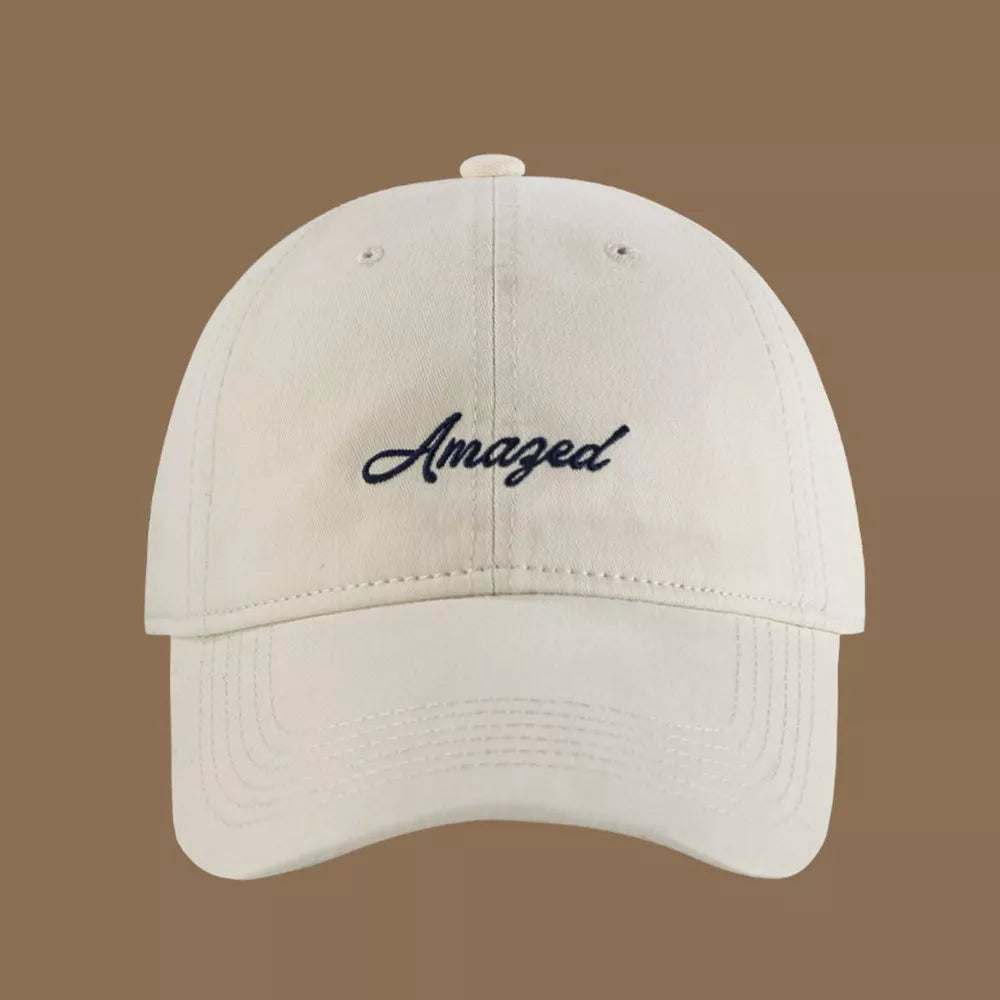 Cream white cotton baseball cap with embroidered "Amazed" text