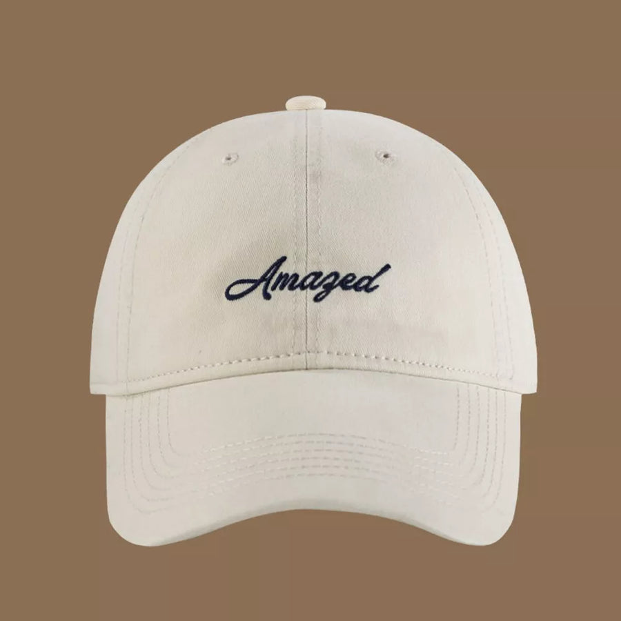 Cream white cotton baseball cap with embroidered "Amazed" text