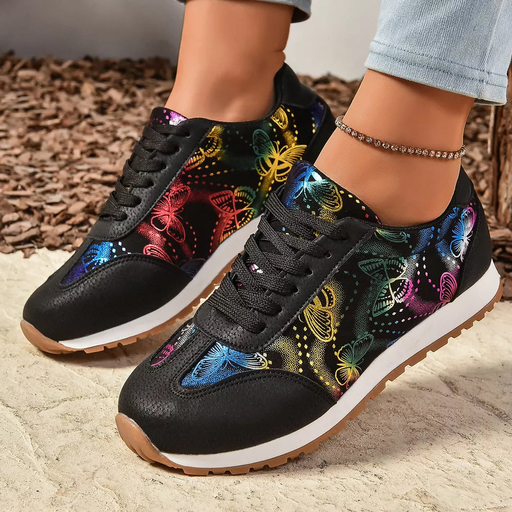 Black casual sneakers with rainbow butterfly print and white soles.