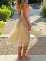 Sheer slip dress in pale yellow with spaghetti straps and a flowing midi skirt.