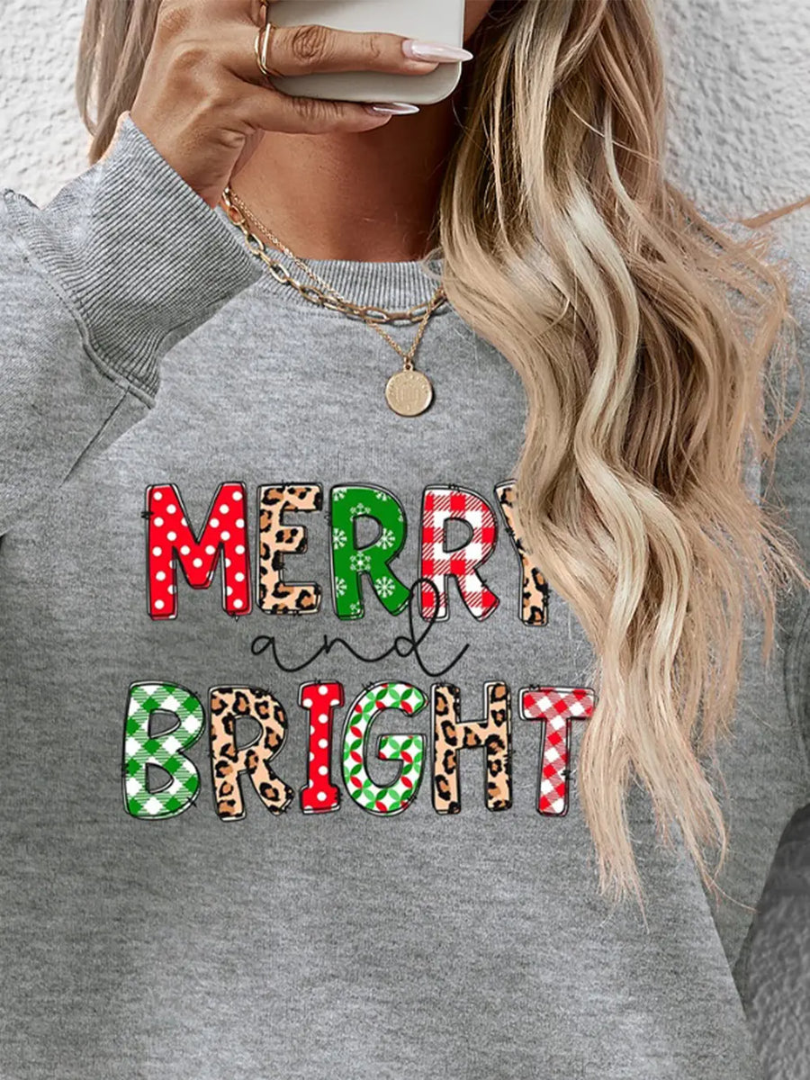 Gray crewneck sweatshirt with "Merry and Bright" graphic in festive patterns like buffalo plaid and leopard print.