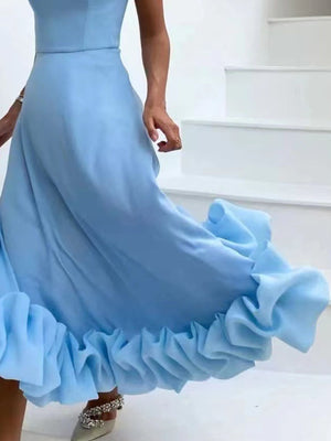 Light blue midi dress with a ruffled hem, flowing fabric, and a sleeveless bodice.