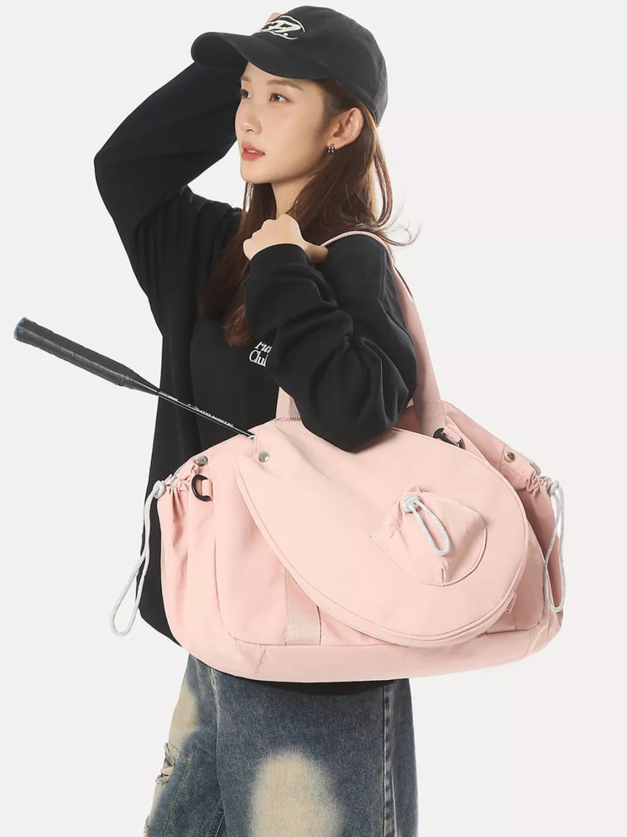 Pink athletic nylon tote bag with racket holder and cinch cord detail.