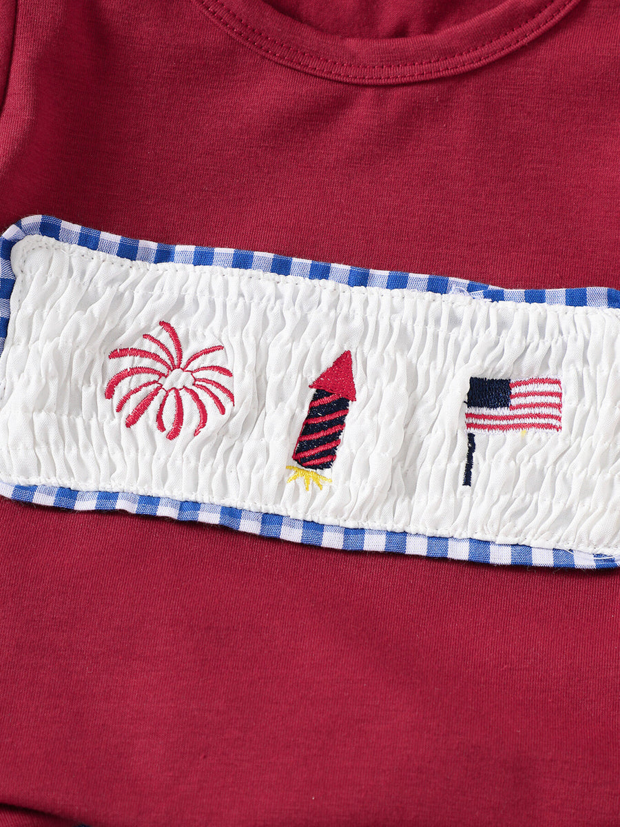 Red baby set with smocked panel embroidery of fireworks, rocket, and American flag.