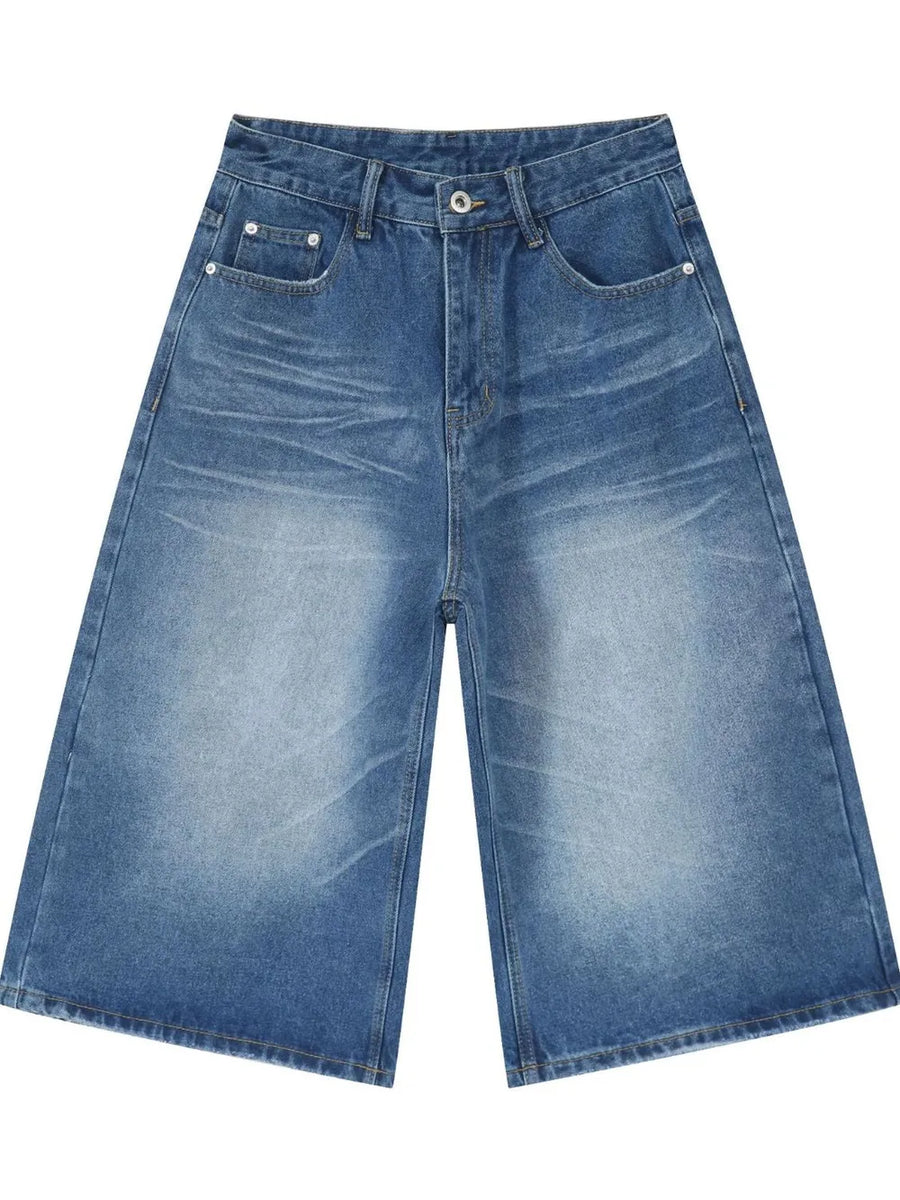 Wide-leg denim culotte shorts in medium blue wash with whiskering and distressed details.