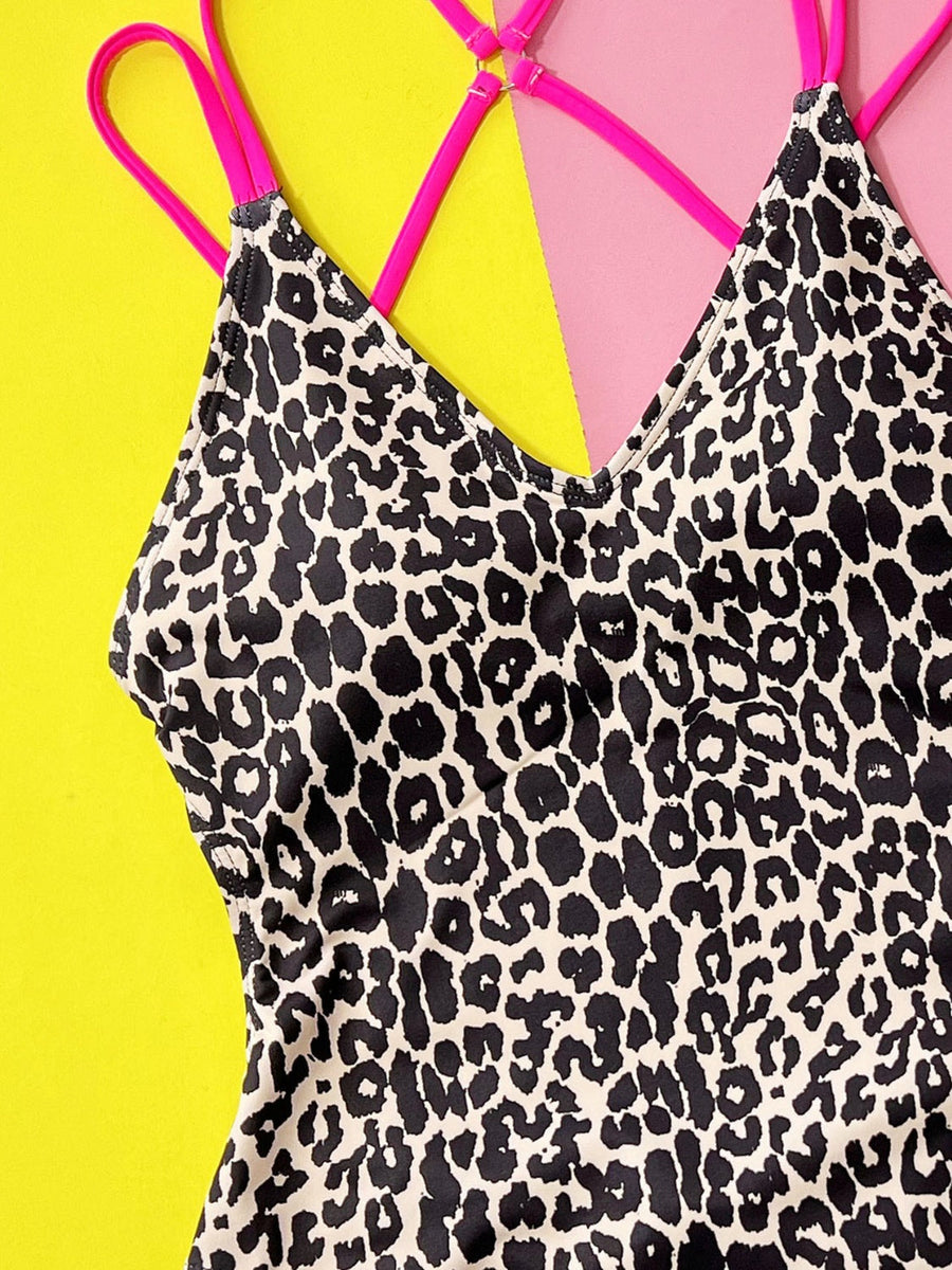 One-piece swimsuit with neon pink strappy back and black leopard print.
